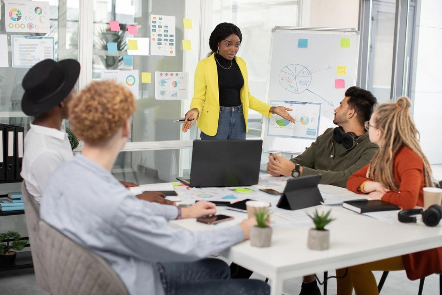 Manager presenting analytics to a diverse team in a Dubai office meeting room
