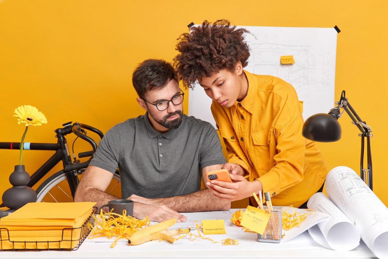 Two colleagues reviewing employee performance notes at a bright workspace